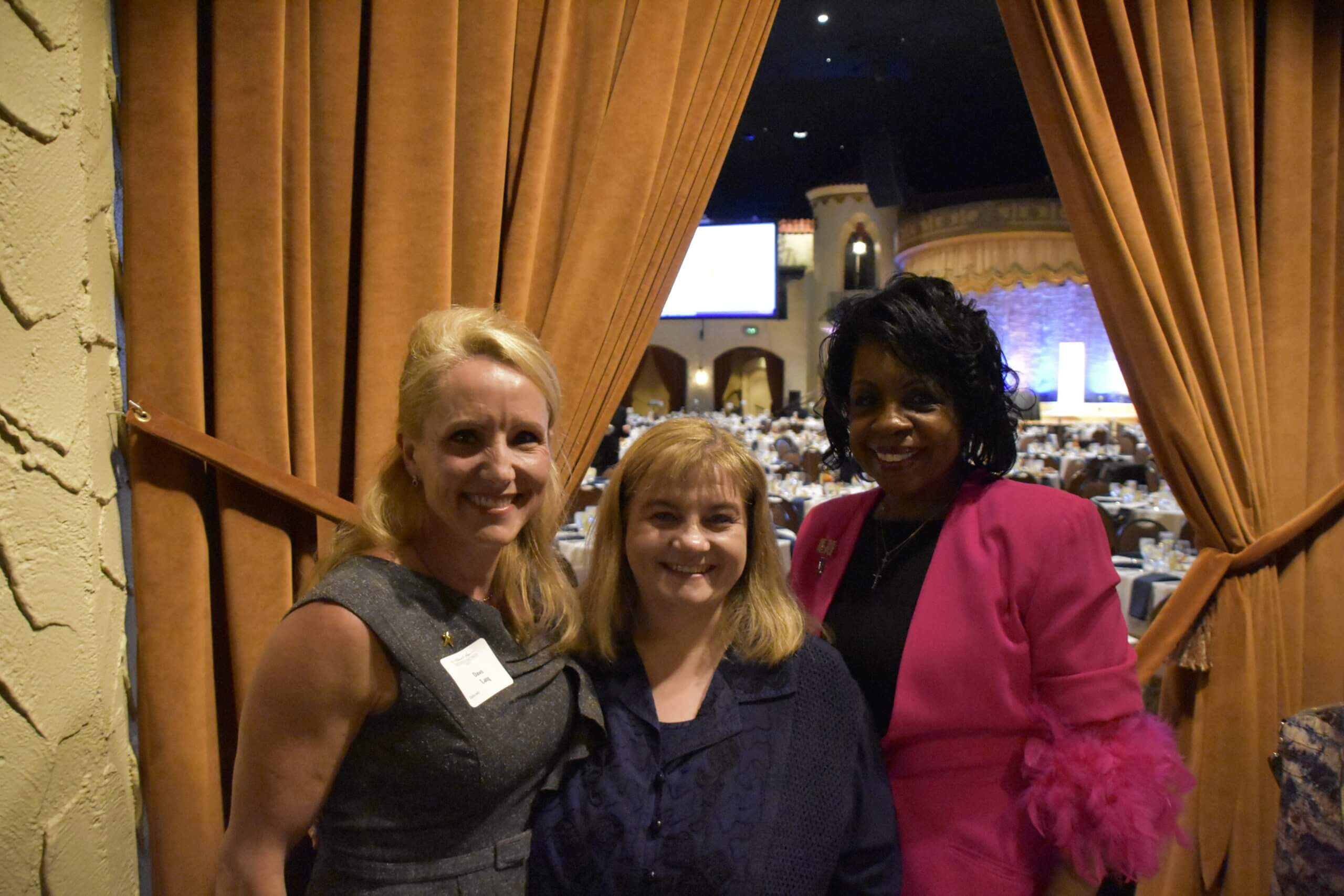 Three event attendees in front of the event hall