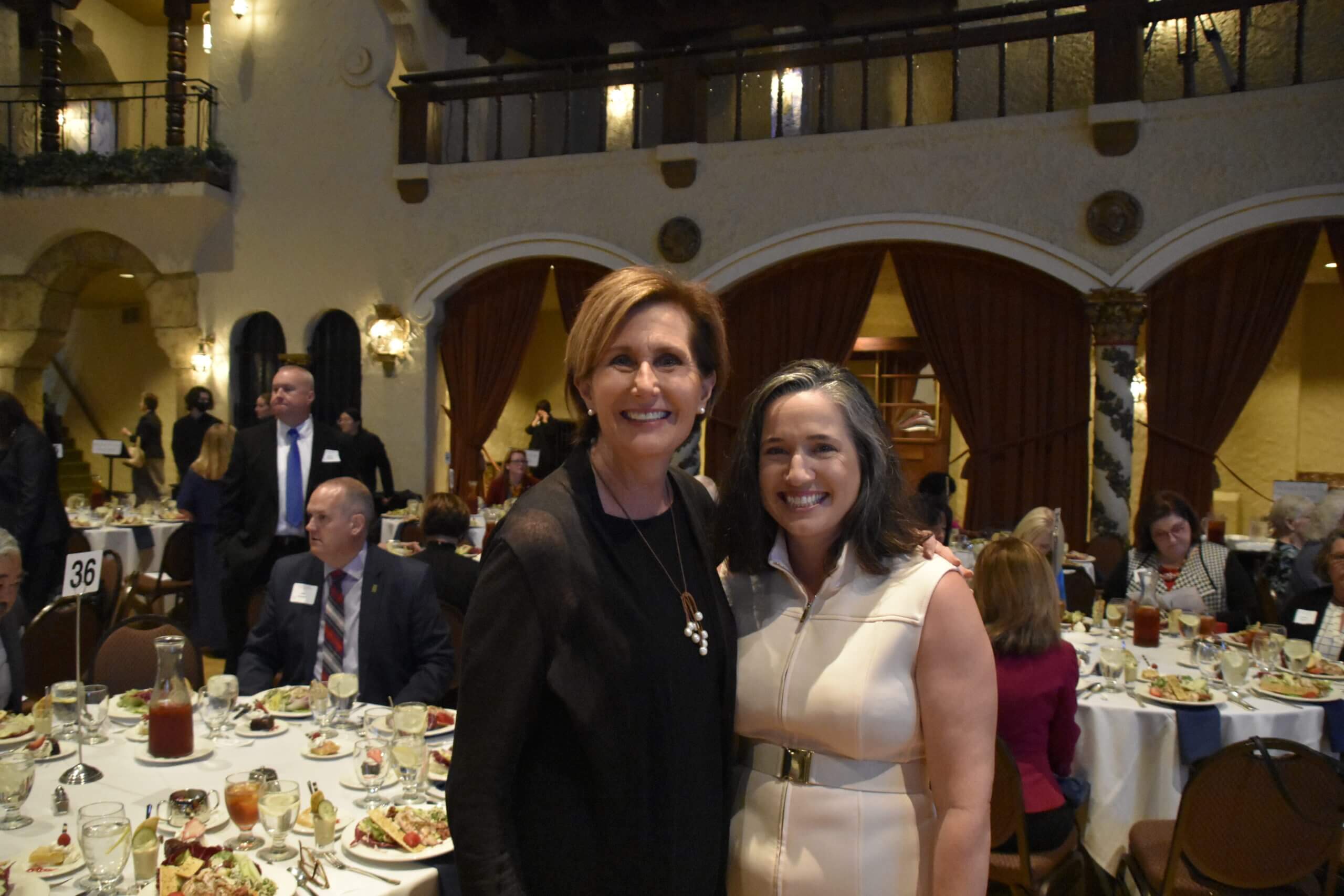 Two event attendees smile at the event