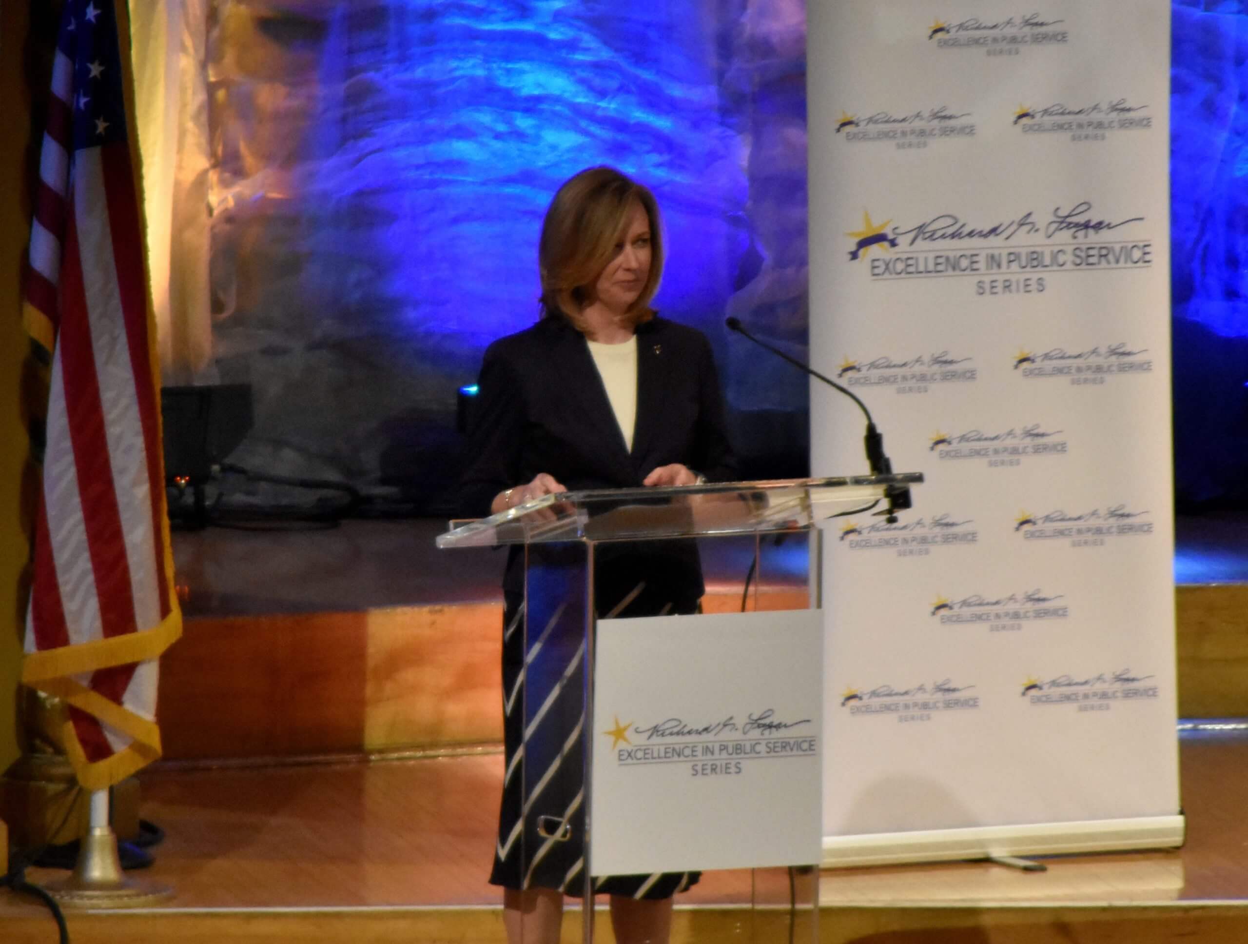 A speaker addresses event attendees from the podium