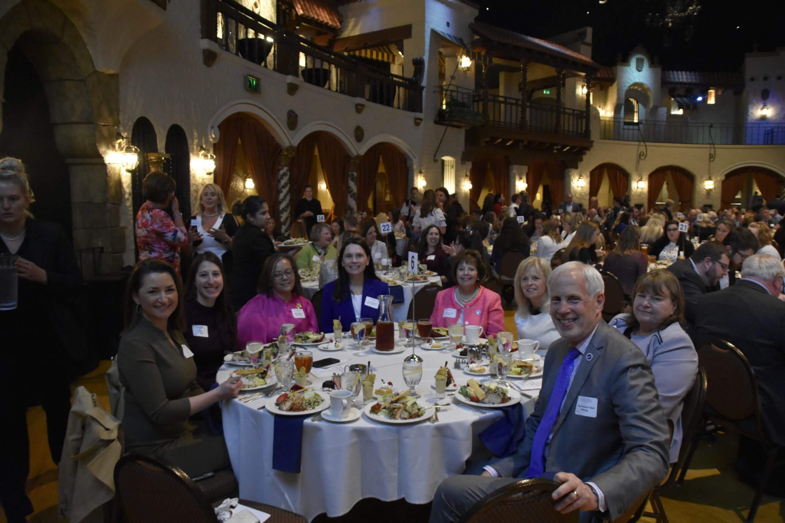 Event attendees smile at their table