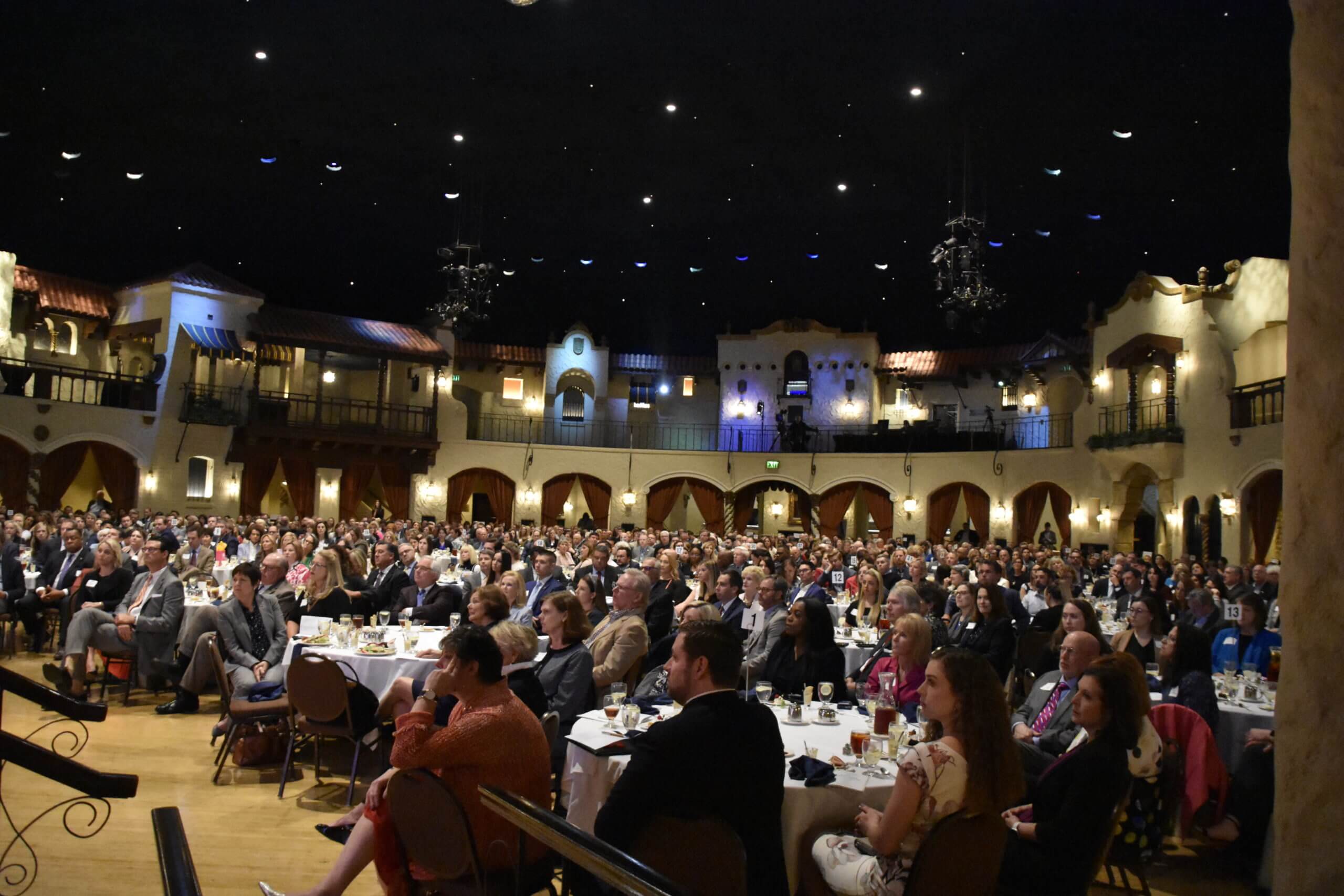 Event attendees watch the stage from their tables