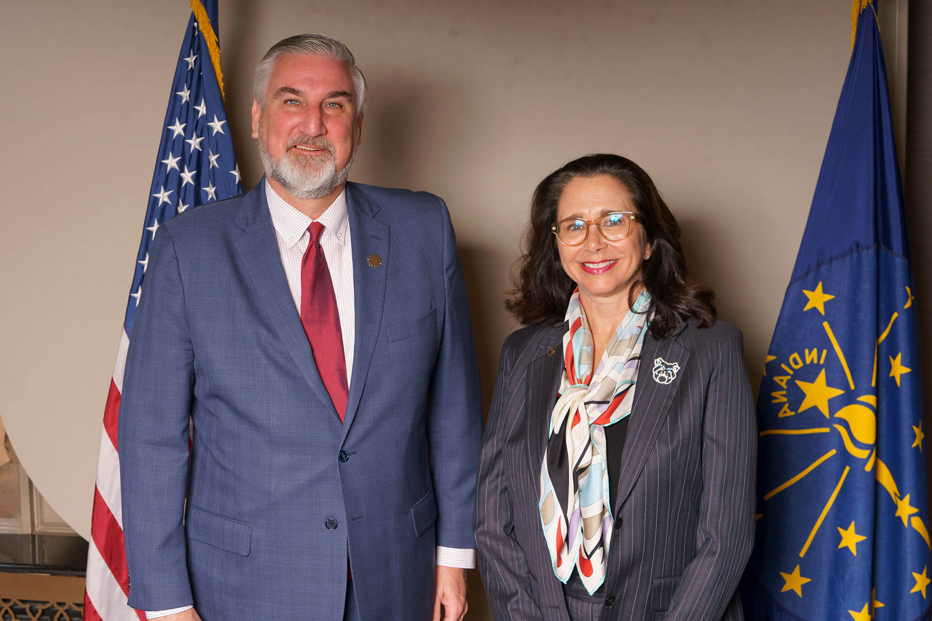 Lugar Series member wearing a colorful scarf with a bearded man at luncheon