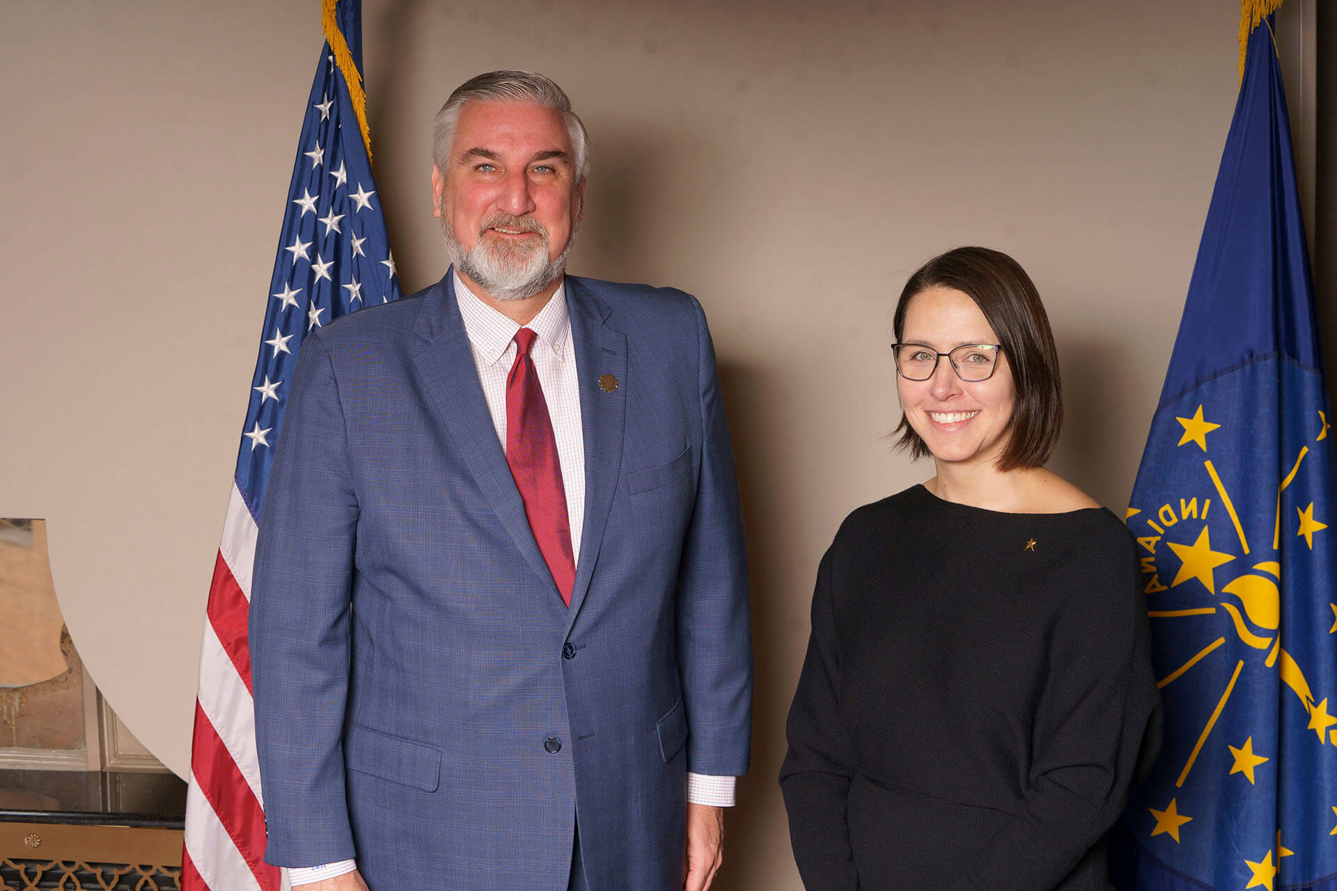 Lugar Series member and speaker pose in front of flags