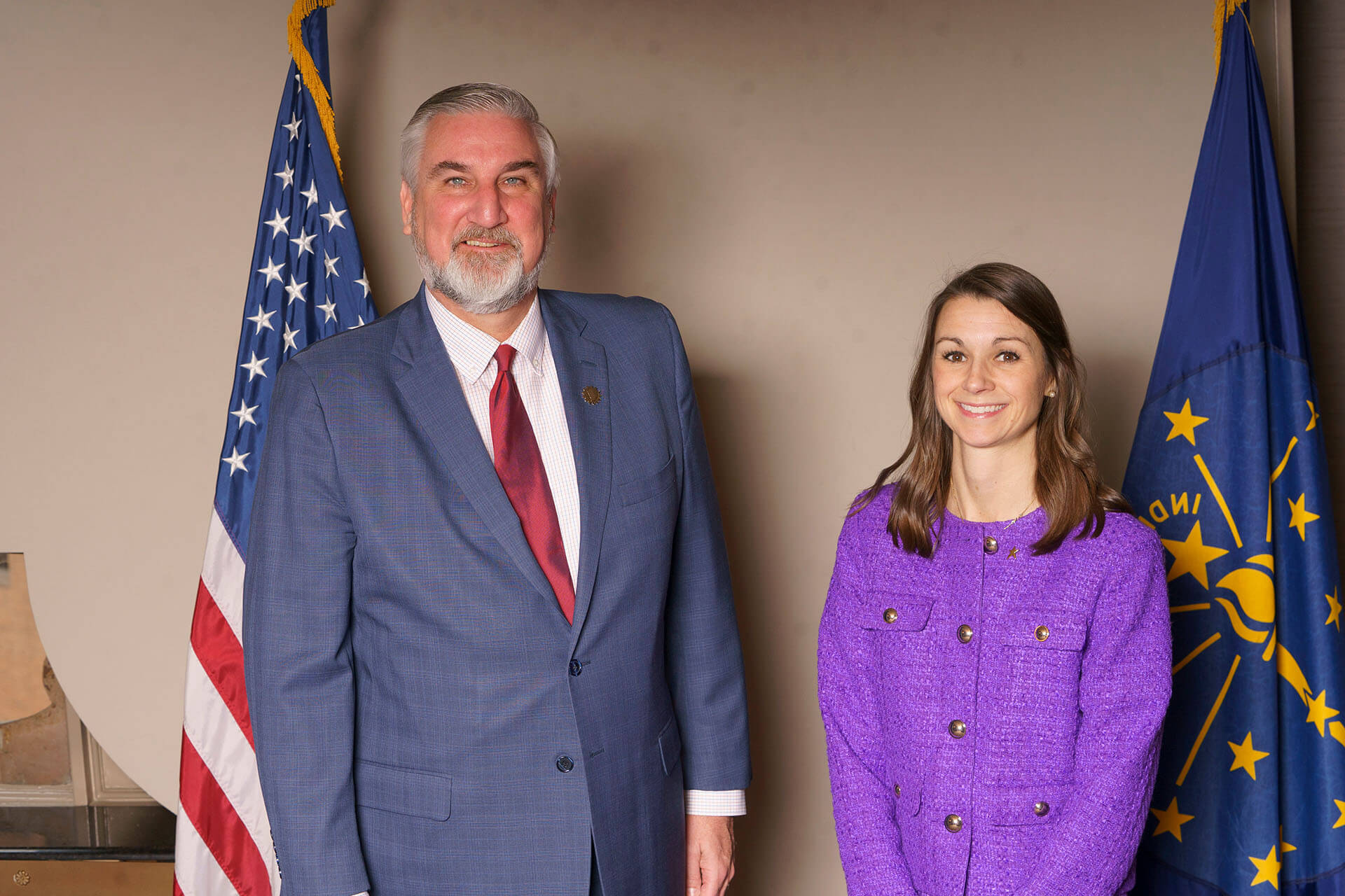 Lugar Series member wearing a purple outfit with event speaker and flags