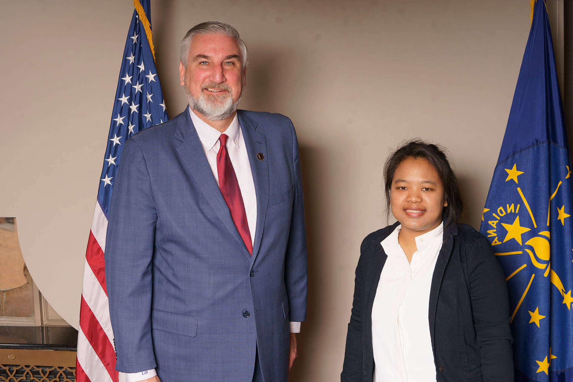 Lugar Series member and speaker in front of flags