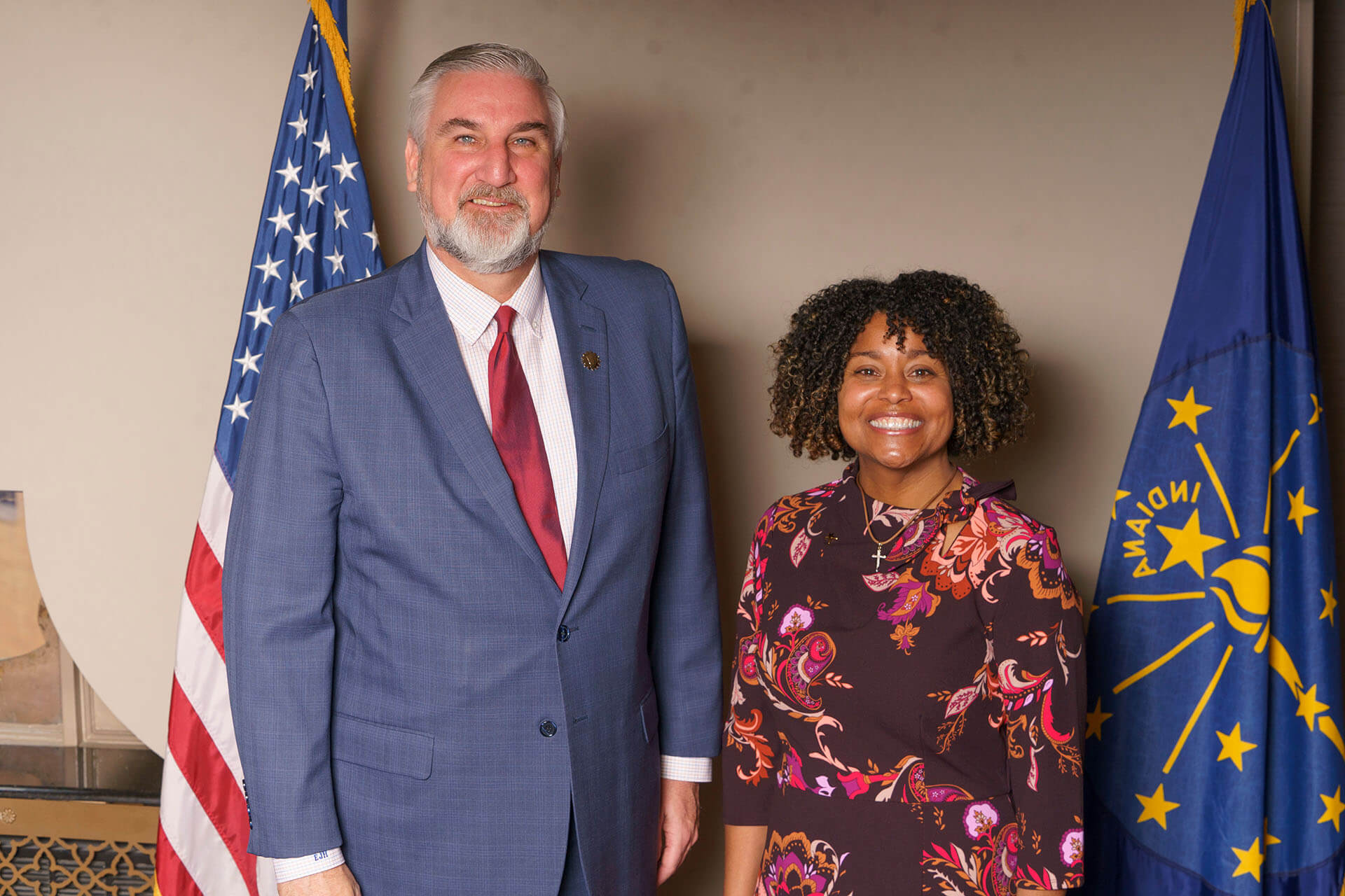 Lugar Series member wearing a flowery dress stands with Annual Luncheon speaker