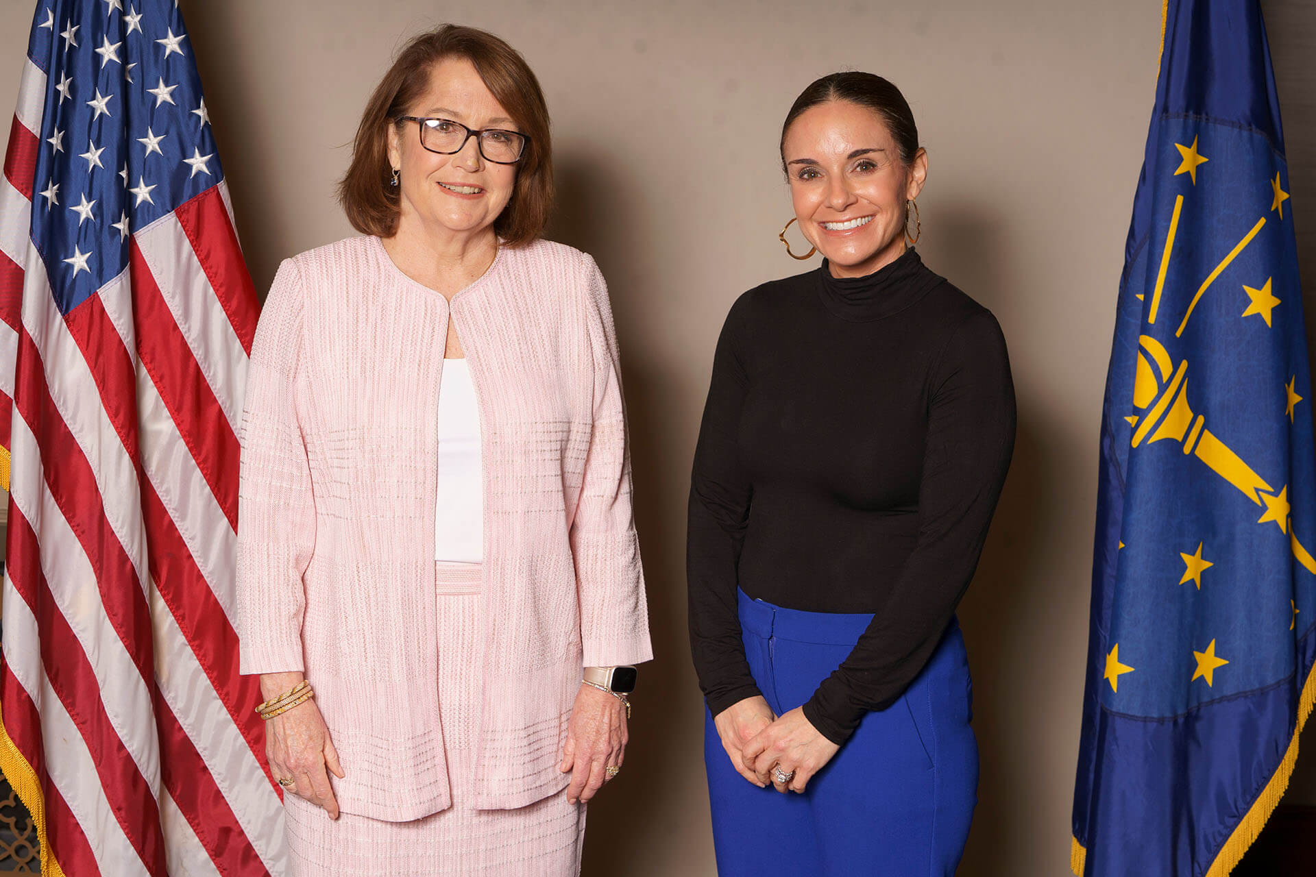 Lugar Series women smiling in front of American and Indiana flags