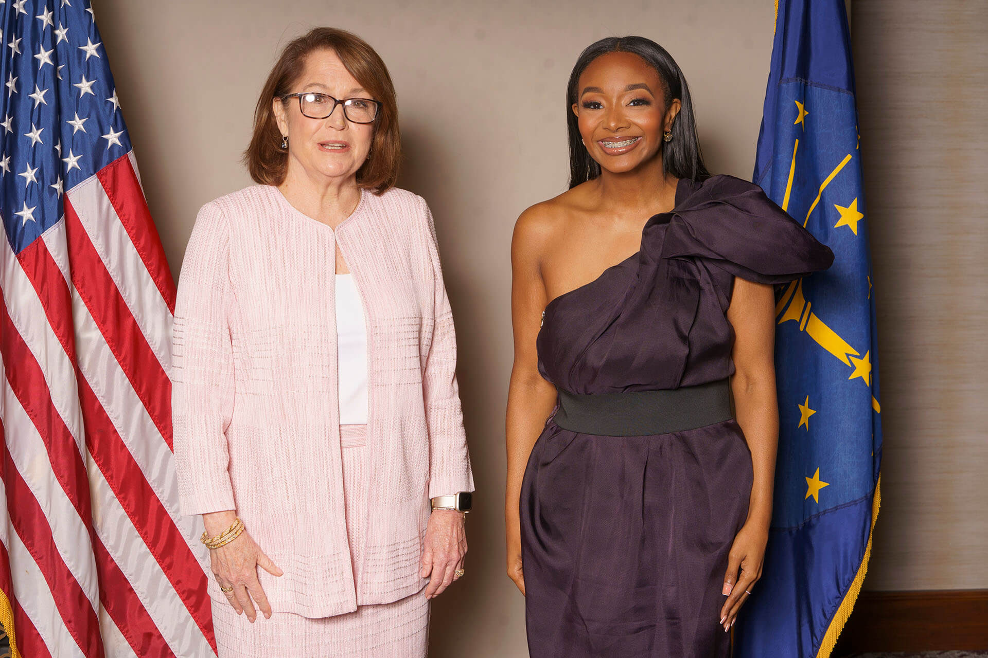 Lugar Series women in front of state and national flags