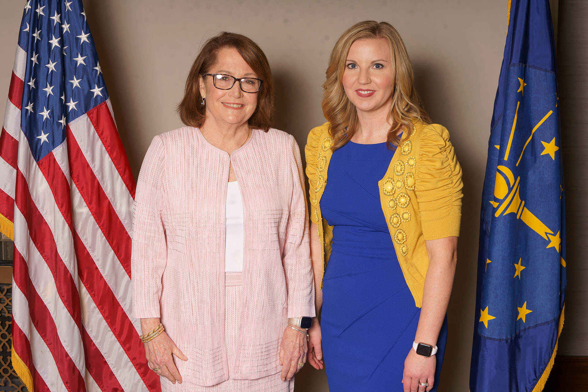 Smiling women in front of Indiana and American flags