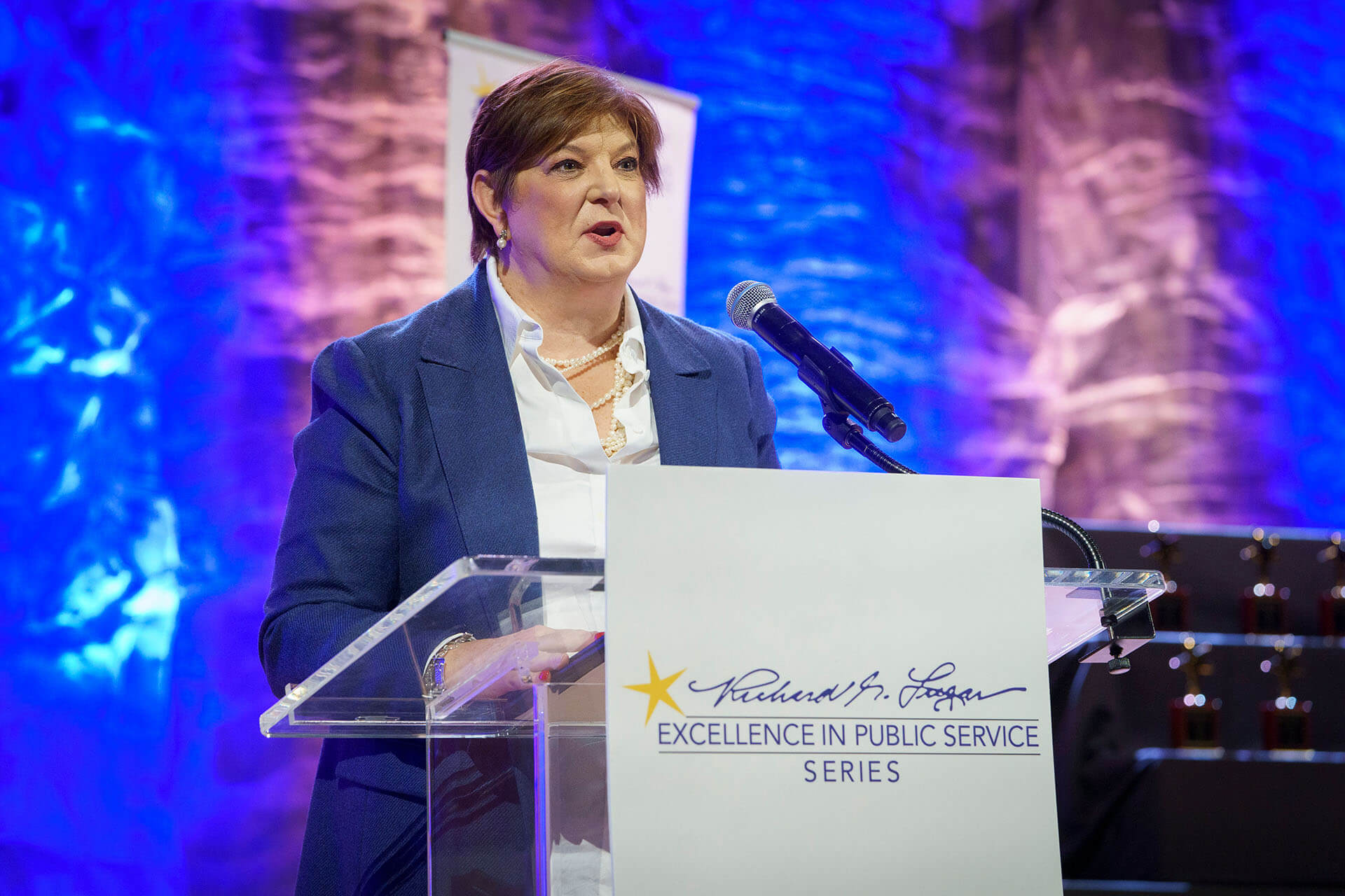 A Lugar Series member addresses the crowd from a podium