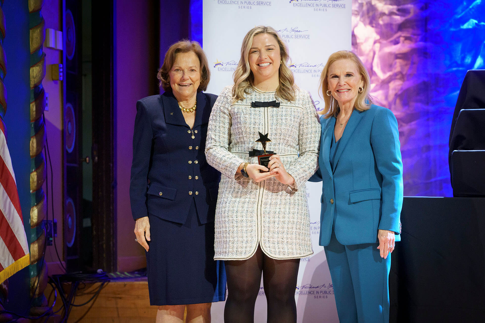 Lugar Series member wearing a scarf is presented with an award at the Annual Luncheon