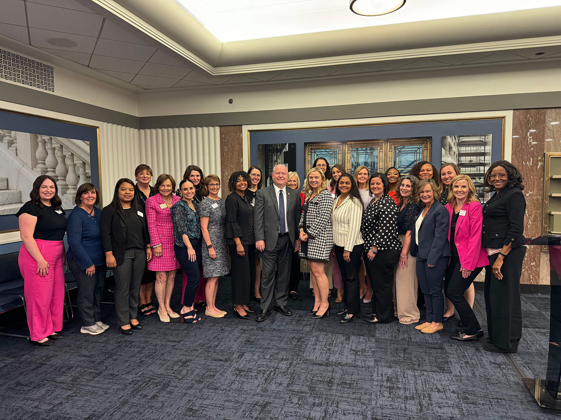 Lugar Series members with guest speaker wearing a gray suit at leadership event
