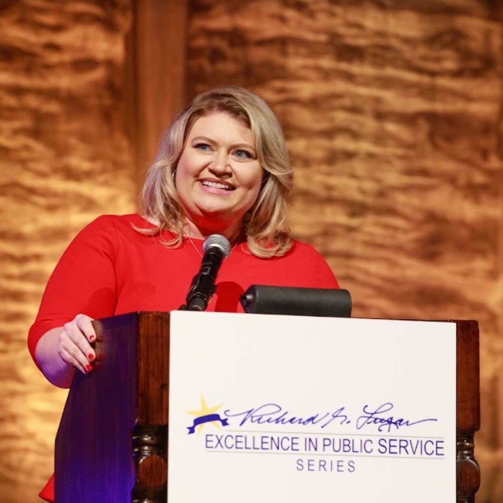 Blonde woman speaks at podium for Lugar Series 2021 Event