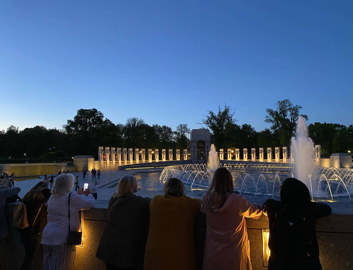 Lugar Series group stands around fountain of World War II Memorial