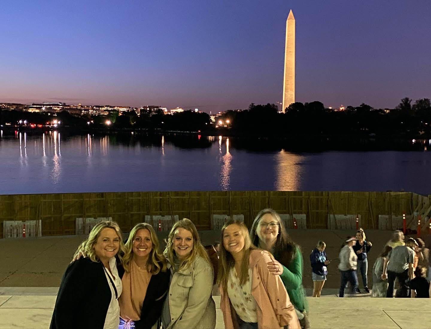 Lugar Series group stands near the Potomac with Washington Monument behind them