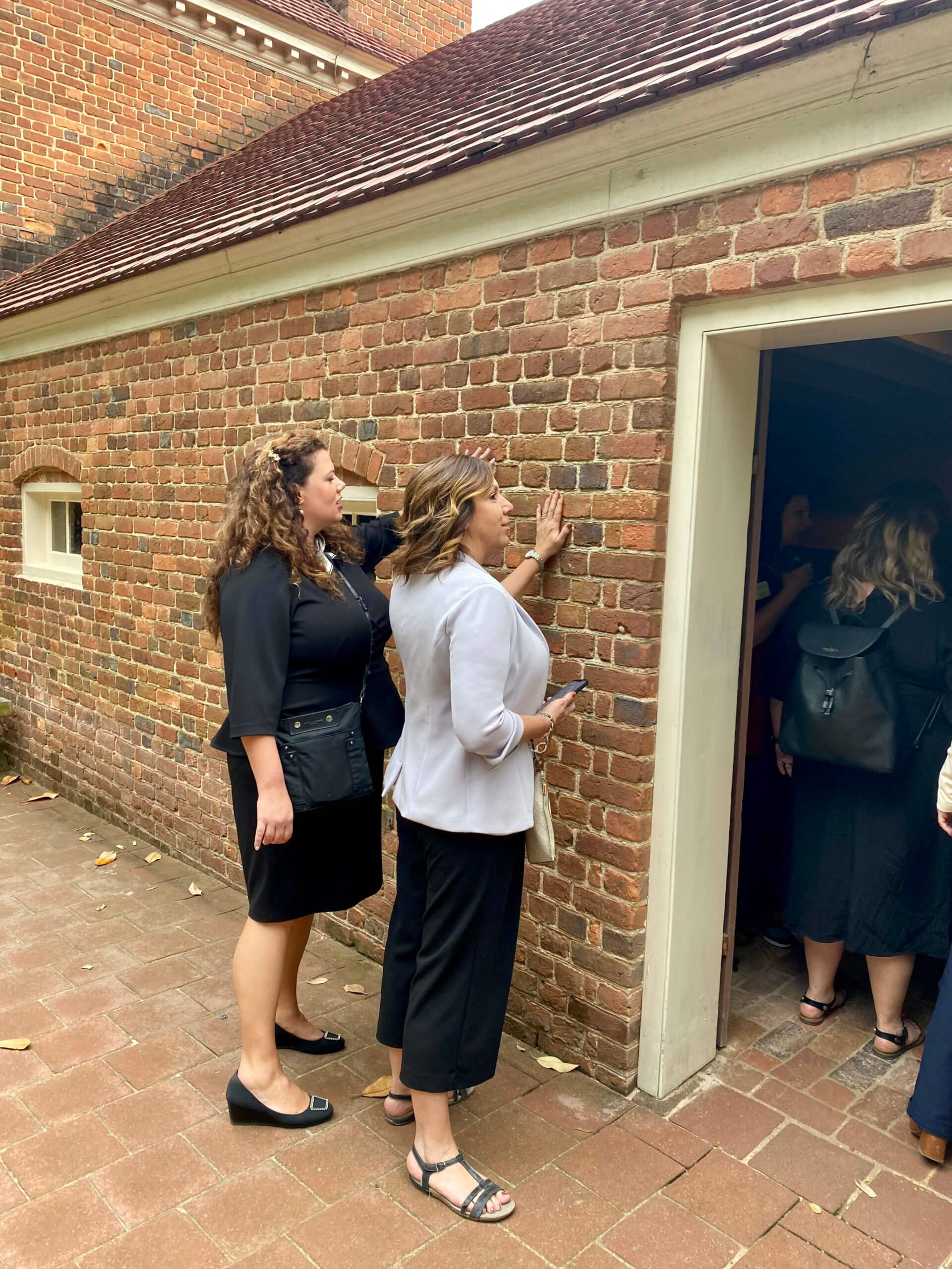 Lugar Series women touching brick wall